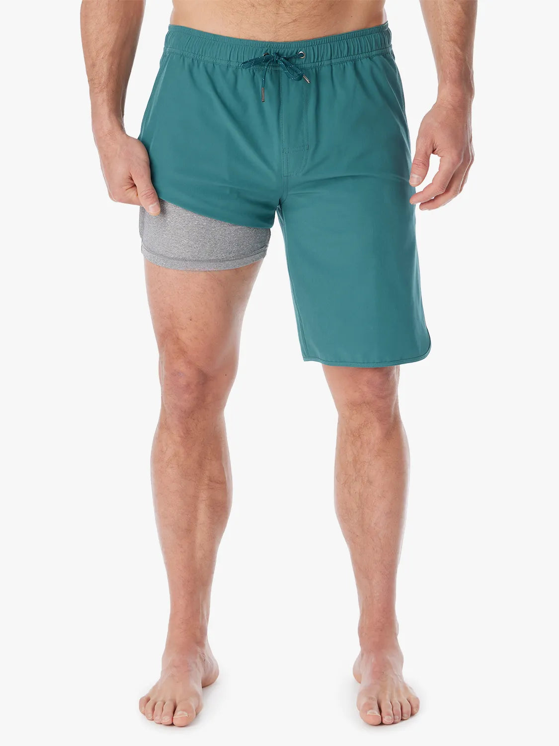 Person wearing 10 inch anchor trunks in seapine color, showing the liner on a white background.