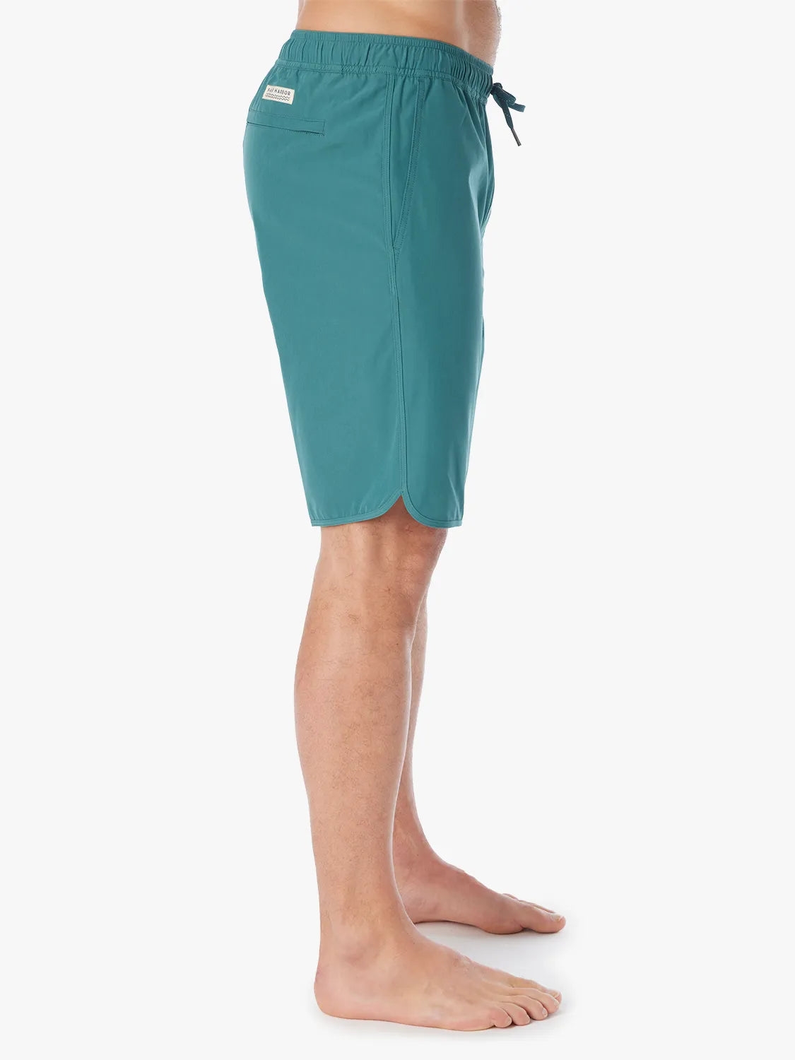 Person wearing 10 inch anchor trunks in seapine color, showing the side view on a white background.