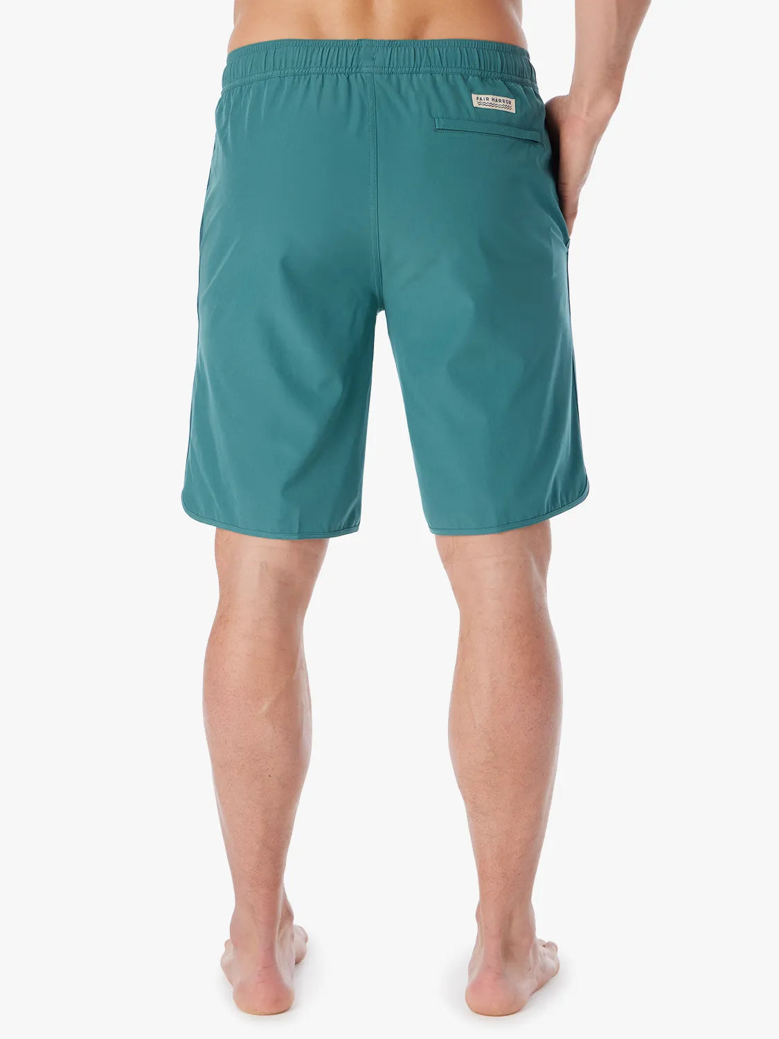 Person wearing 10 inch anchor trunks in seapine color, showing the back view on a white background.