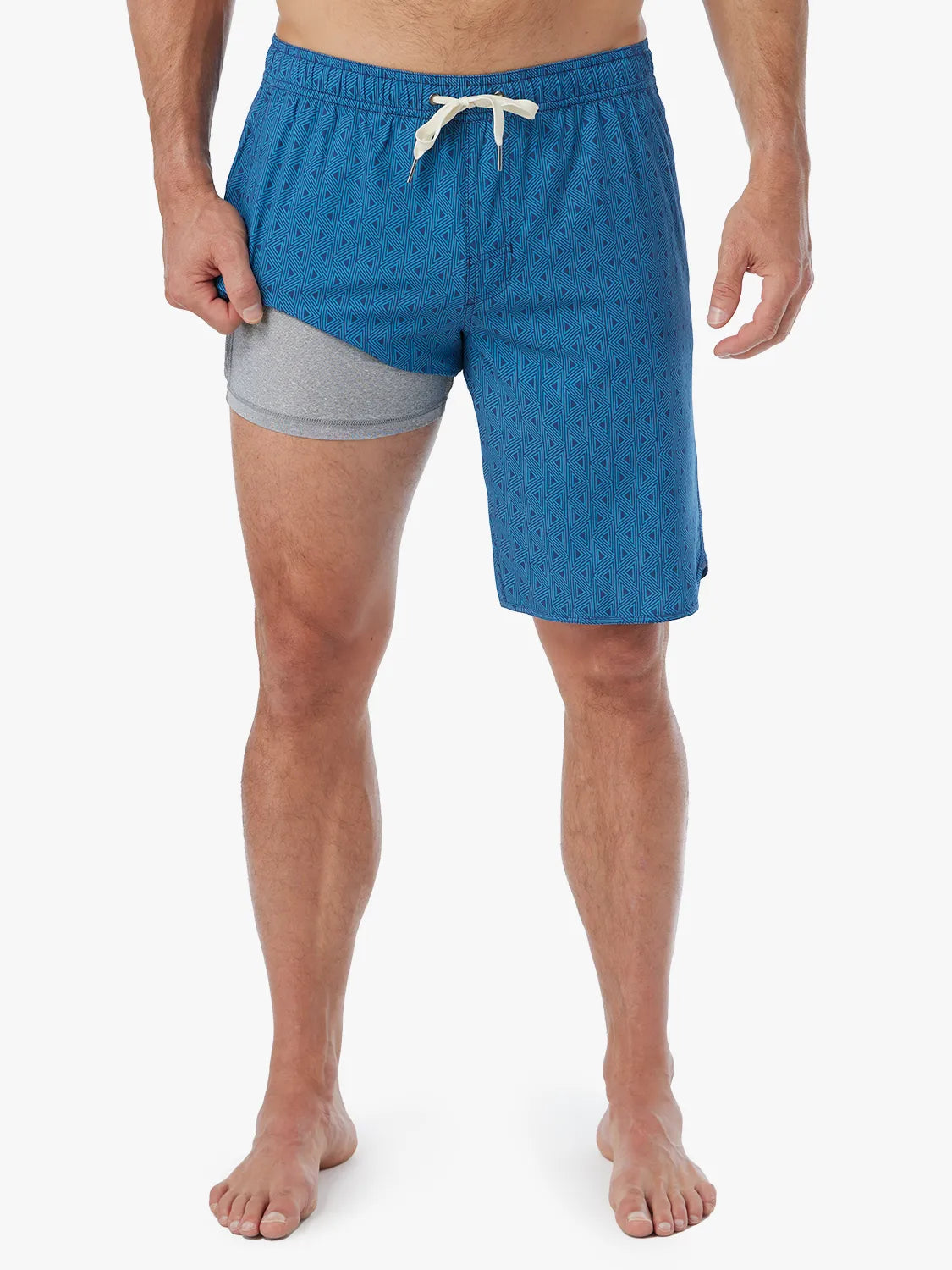 Person wearing electric blue geometric patterned Anchor Trunk in 10 inch inseam with a drawstring waistband and showing the liner.