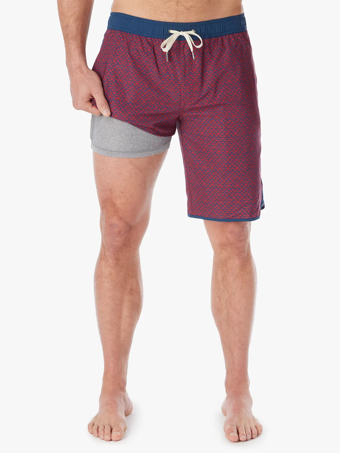 Person wearing a pair of Anchor Trunks with a nautical red wavy geo pattern in 10 Inch inseam. Featuring a drawstring waist and showing the liner, with a white background.