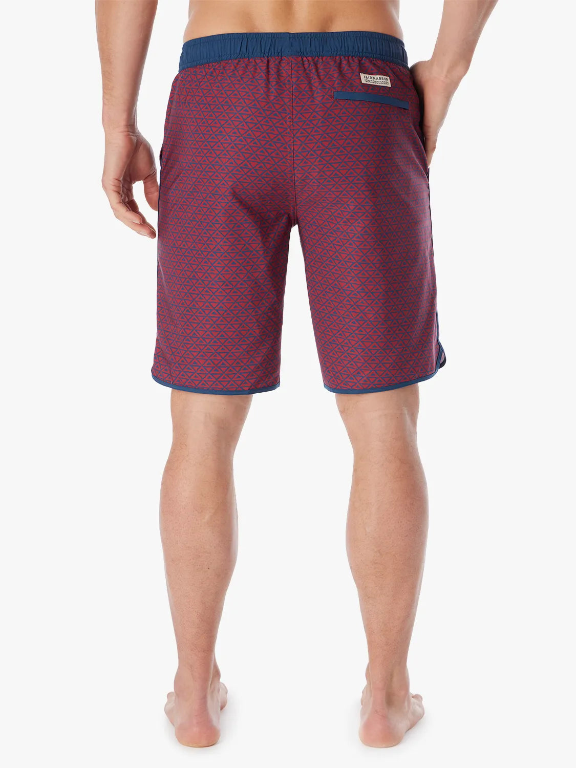 Person wearing a pair of Anchor Trunks with a nautical red wavy geo pattern in 10 Inch inseam. Featuring a drawstring waist and back view of trunk, with a white background.