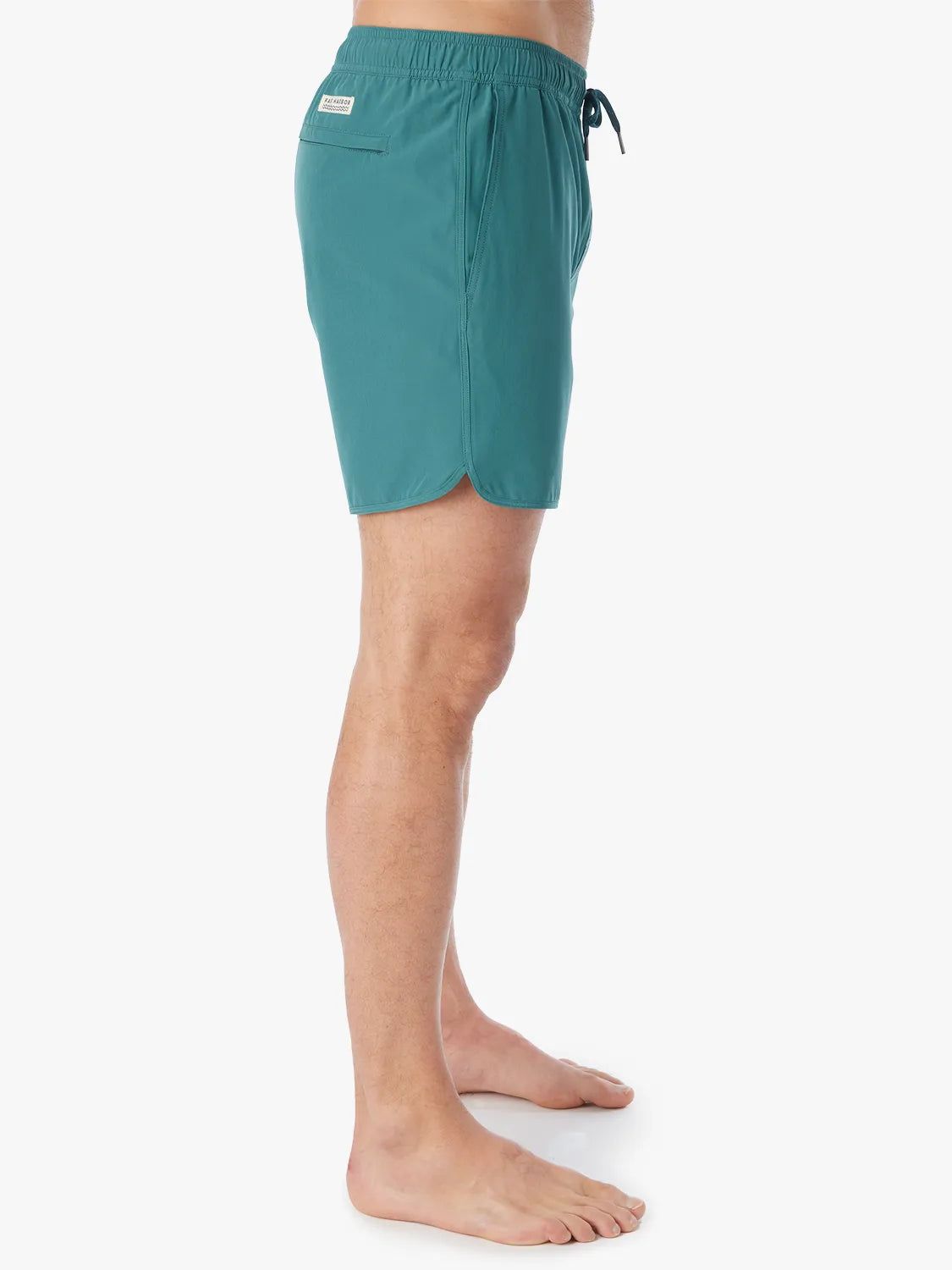 Person wearing 6 inch anchor trunks in seapine color, showing the side view on a white background.