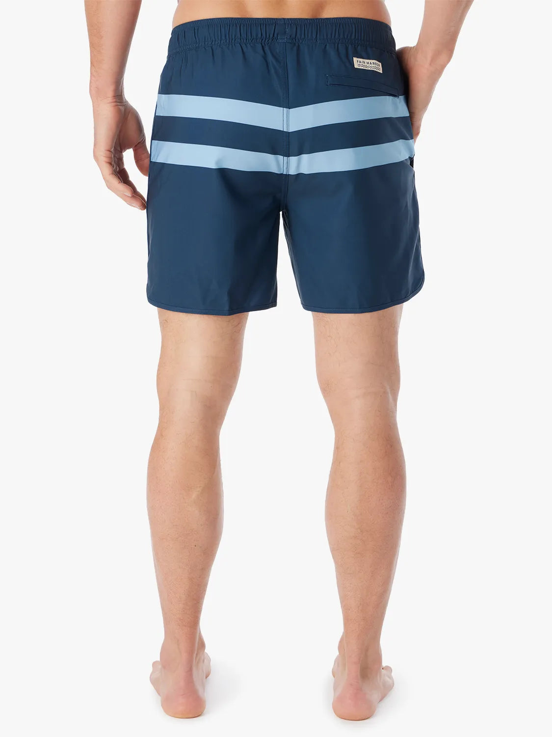 A person wearing a pair of 6 inch navy anchor trunk shorts with two light blue horizontal stripes and a drawstring waist, showing the back view with a white background.