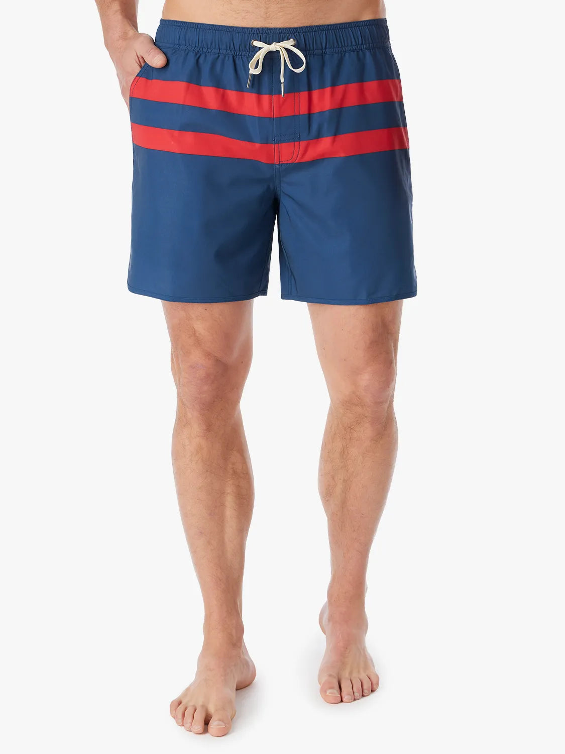 A person wearing a pair of 6 inch navy anchor trunk shorts with two red horizontal stripes and a drawstring waist with a white background.
