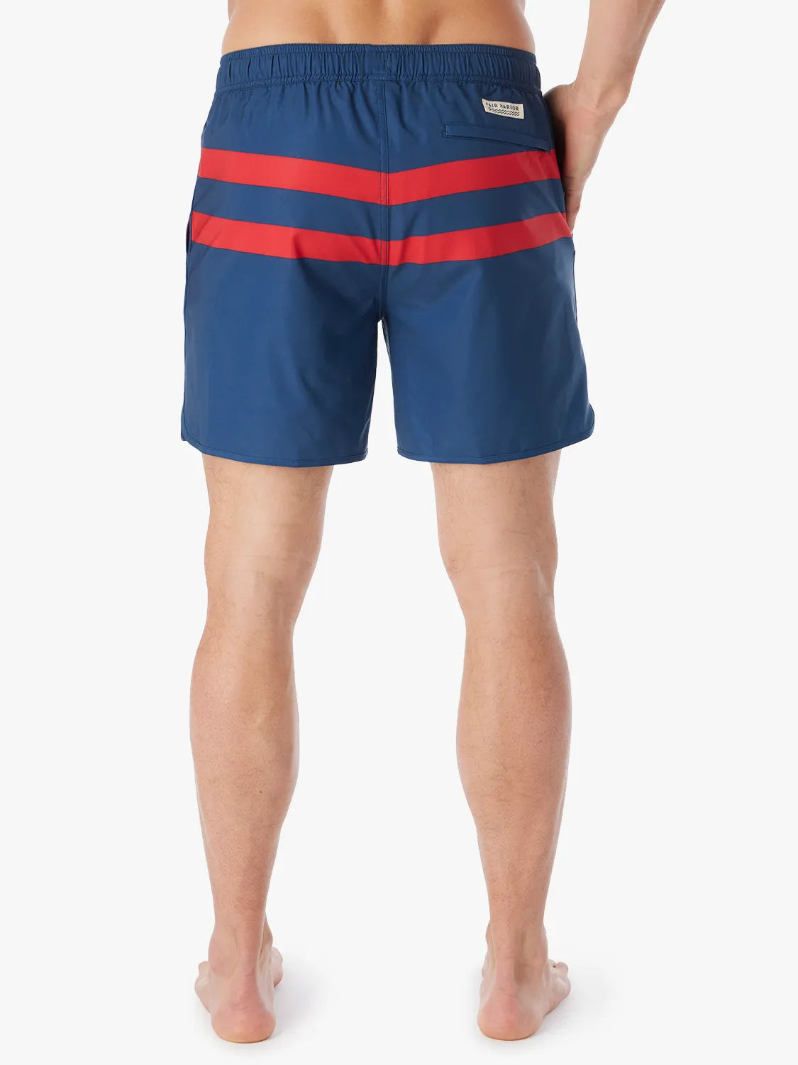 A person wearing a pair of 6 inch navy anchor trunk shorts with two red horizontal stripes, showing the back view with a white background.