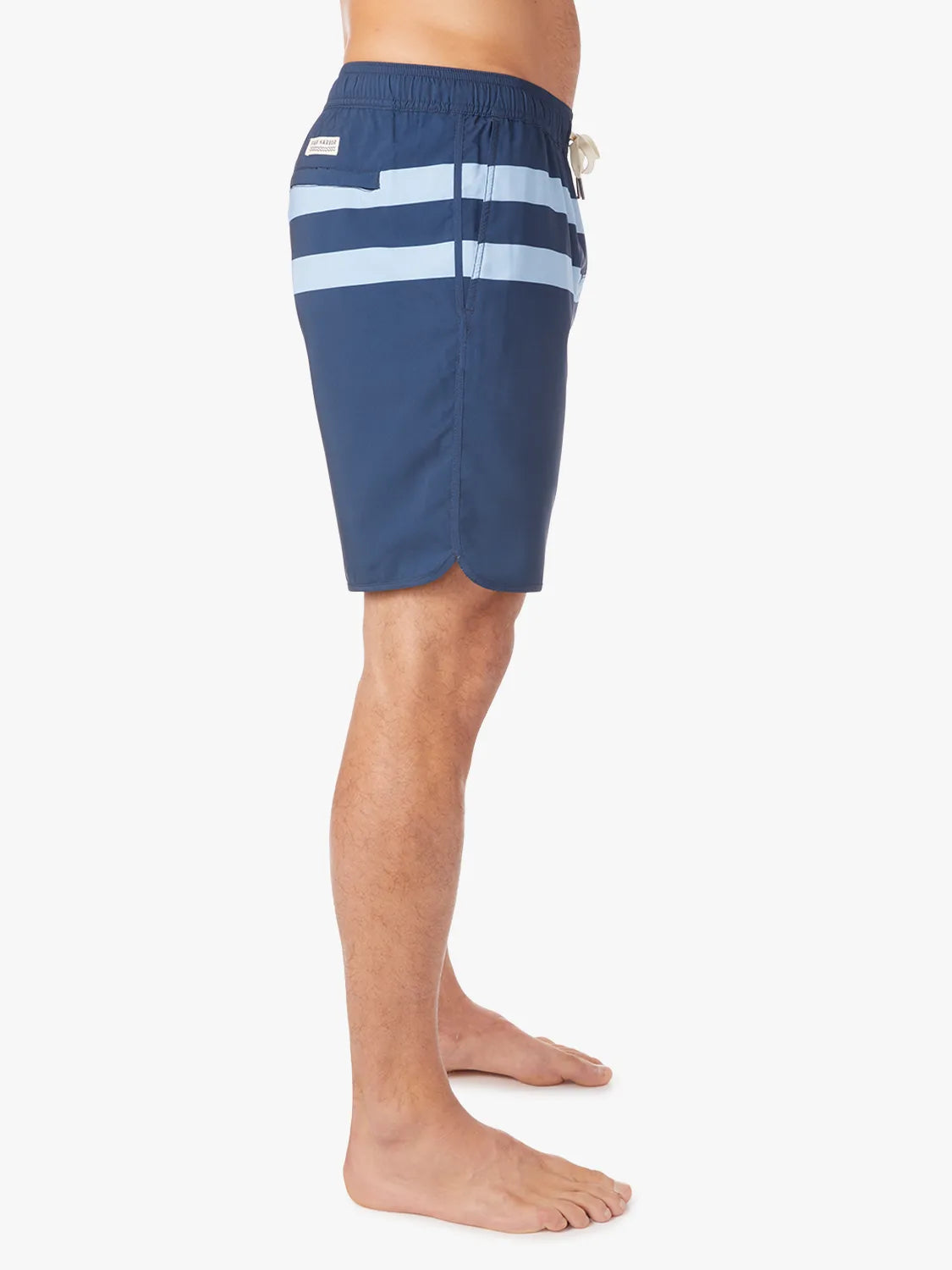 A person wearing a pair of 8 inch navy anchor trunk shorts with two light blue horizontal stripes and a drawstring waist, showing the side view with a white background.