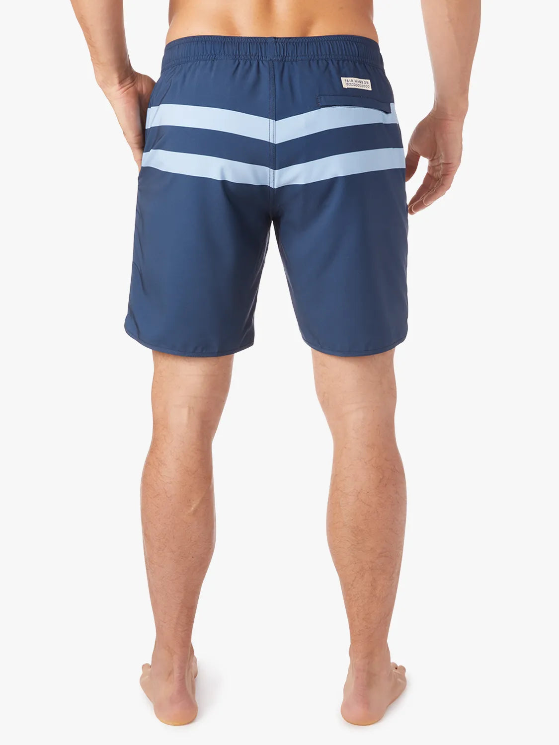 A person wearing a pair of 8 inch navy anchor trunk shorts with two light blue horizontal stripes and a drawstring waist, showing the back view with a white background.