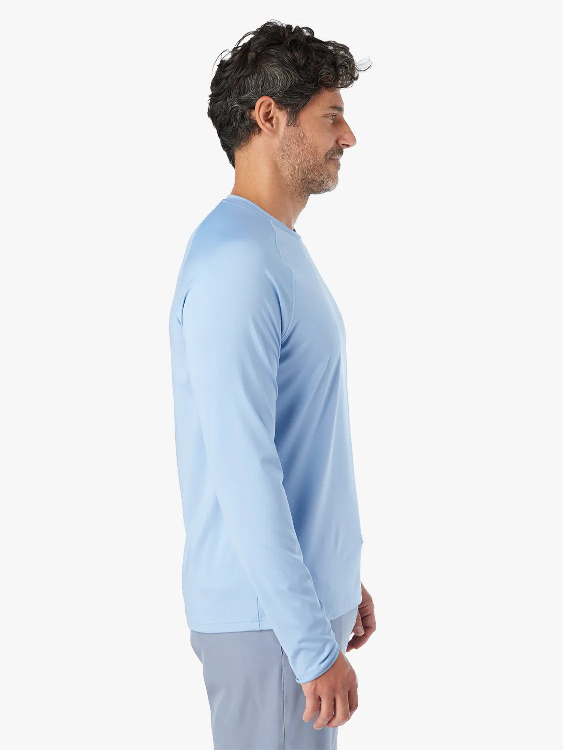 A person wearing the long-sleeved light blue Anchor Rashguard with a crewneck design, showing side view.