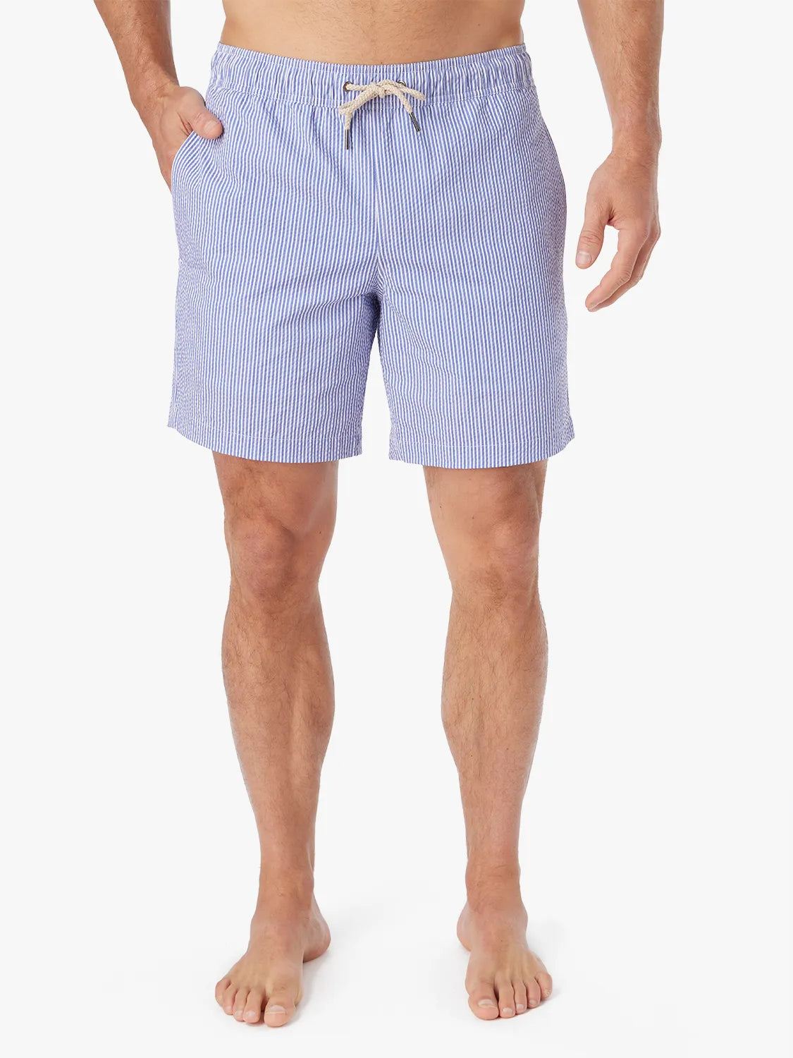 Man wearing a pair of light blue seersucker Bayberry swim trunks with a drawstring elastic waistband.