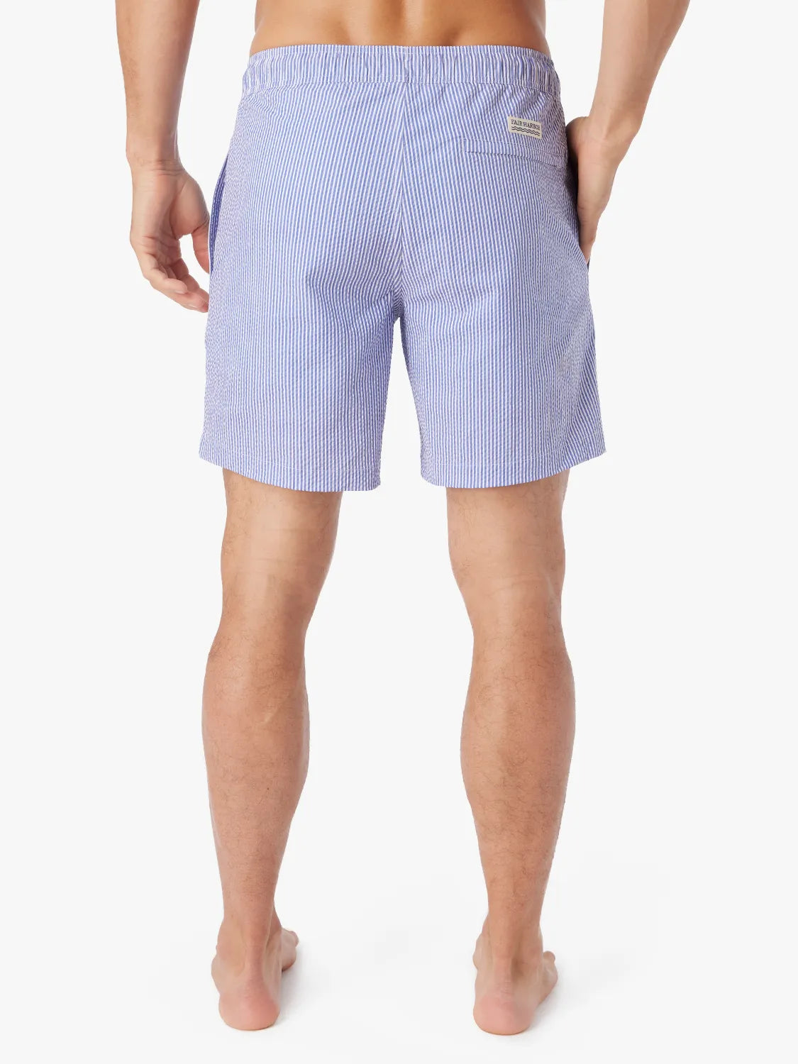 Man wearing a pair of light blue seersucker Bayberry swim trunks with a drawstring elastic waistband, showing the back view.