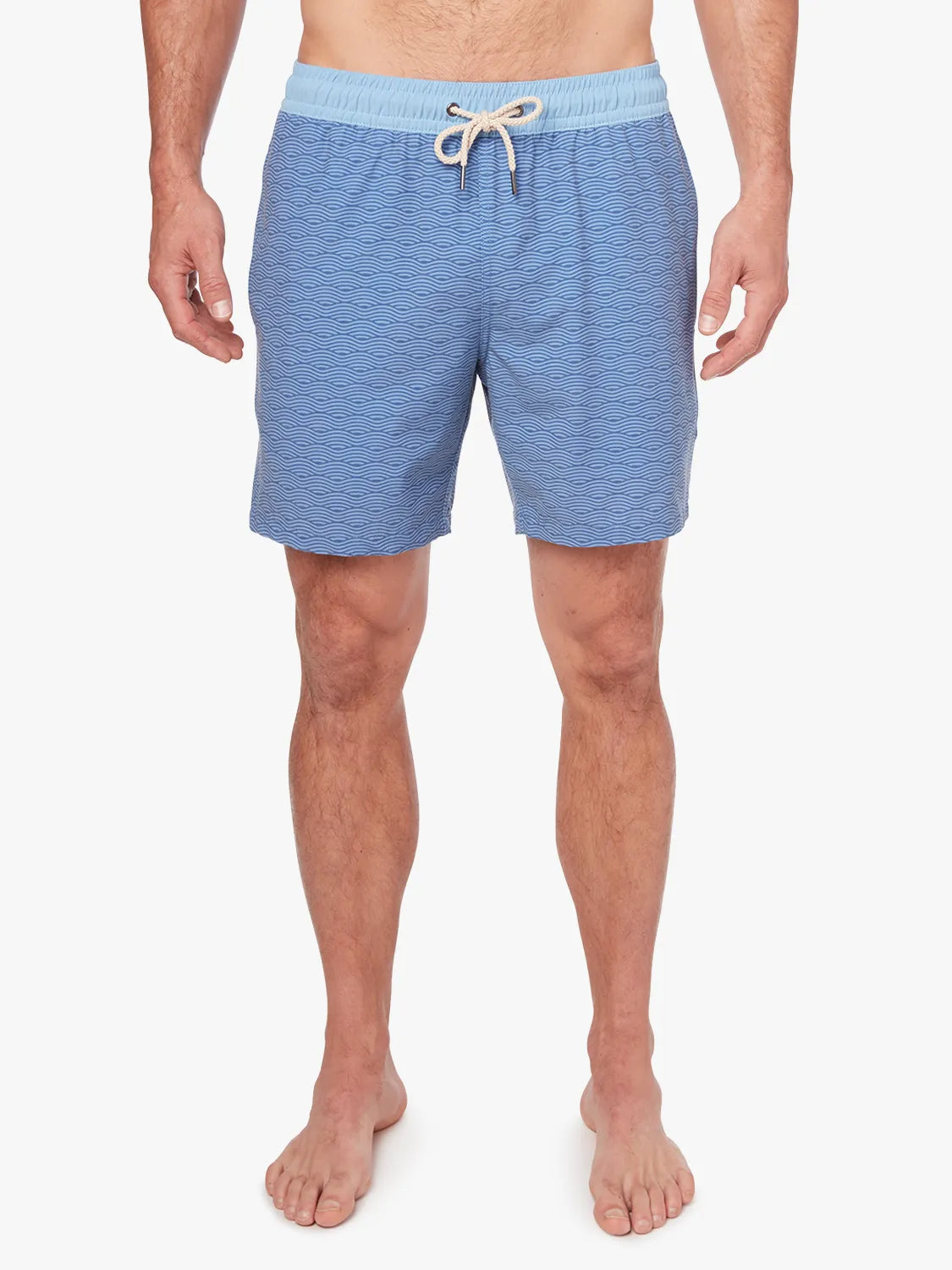 A person wearing a pair of blue waves Bayberry trunks with a drawstring elastic waistband.