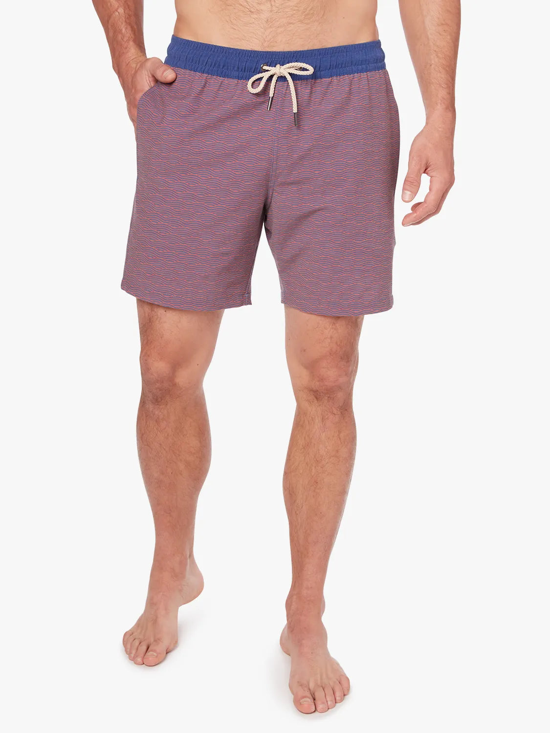 Person wearing a pair of red bayberry trunks with a navy waistband and subtle wave pattern with a white drawstring on a white background.