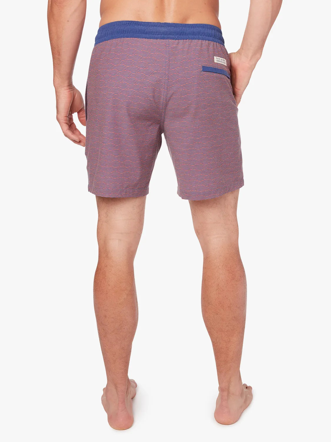 Person wearing a pair of red bayberry trunks with a navy waistband and subtle wave pattern with a white drawstring on a white background. Showing the back view.
