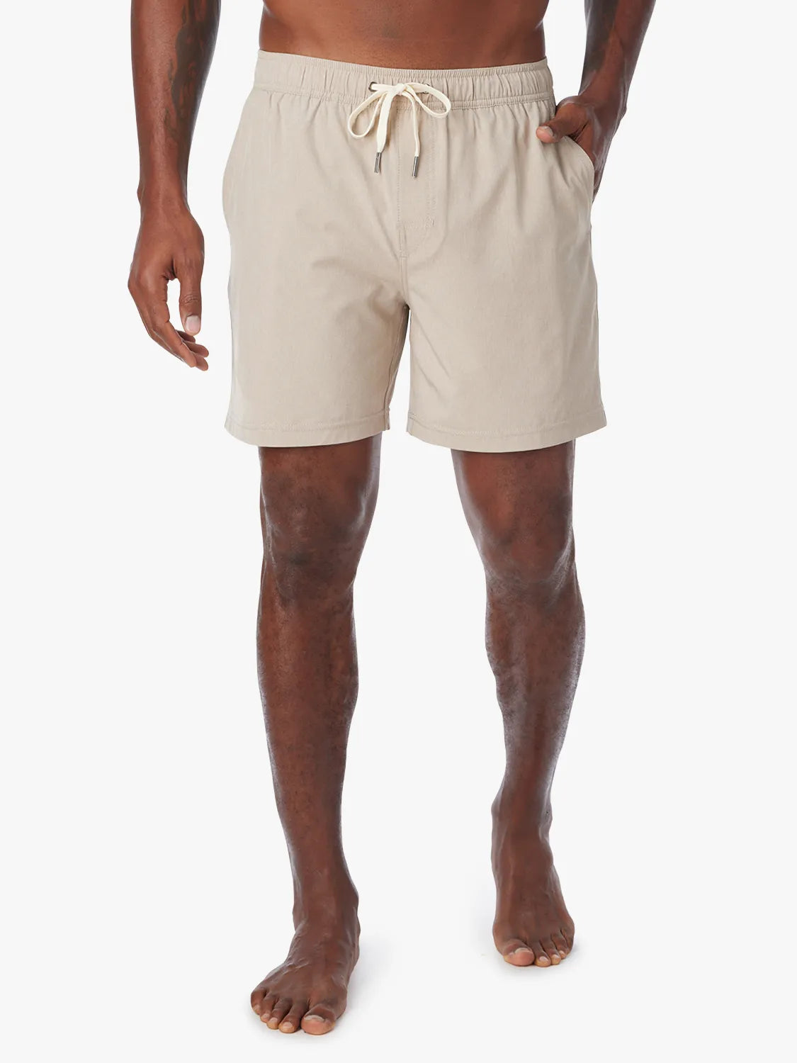 Man wearing a khaki one shorts in 8 inch inseam with a drawstring on a white background