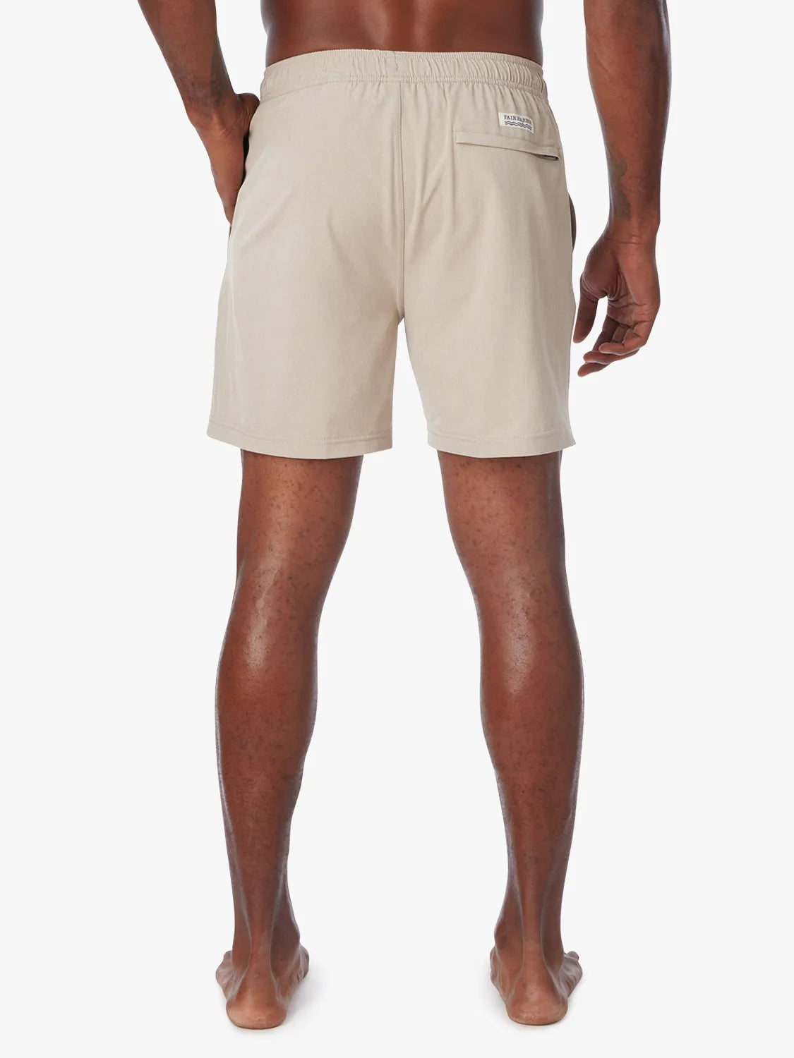 Man wearing a khaki one shorts in 8 inch inseam with a drawstring on a white background, showing the back view.