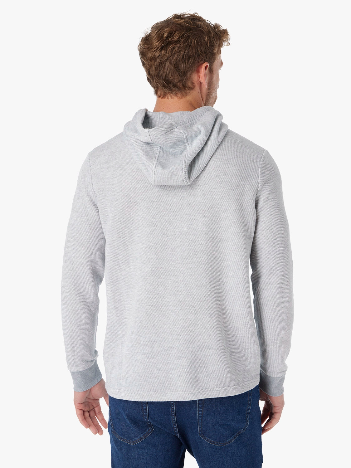 Man wearing a gray tailwind hoodie from behind on a white background with driftwood denim pants.