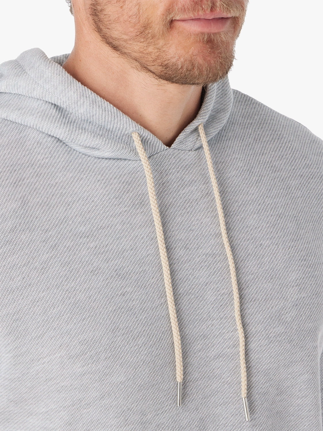 Close up of grey tailwind hoodie fabric with white drawstrings on a white background