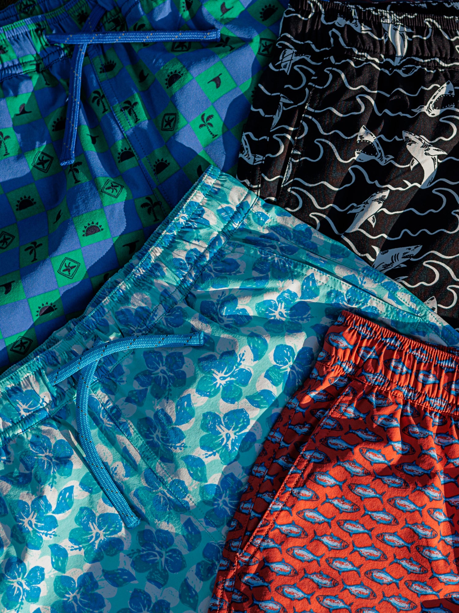 Four kids swim trunks laid out to show the prints. 