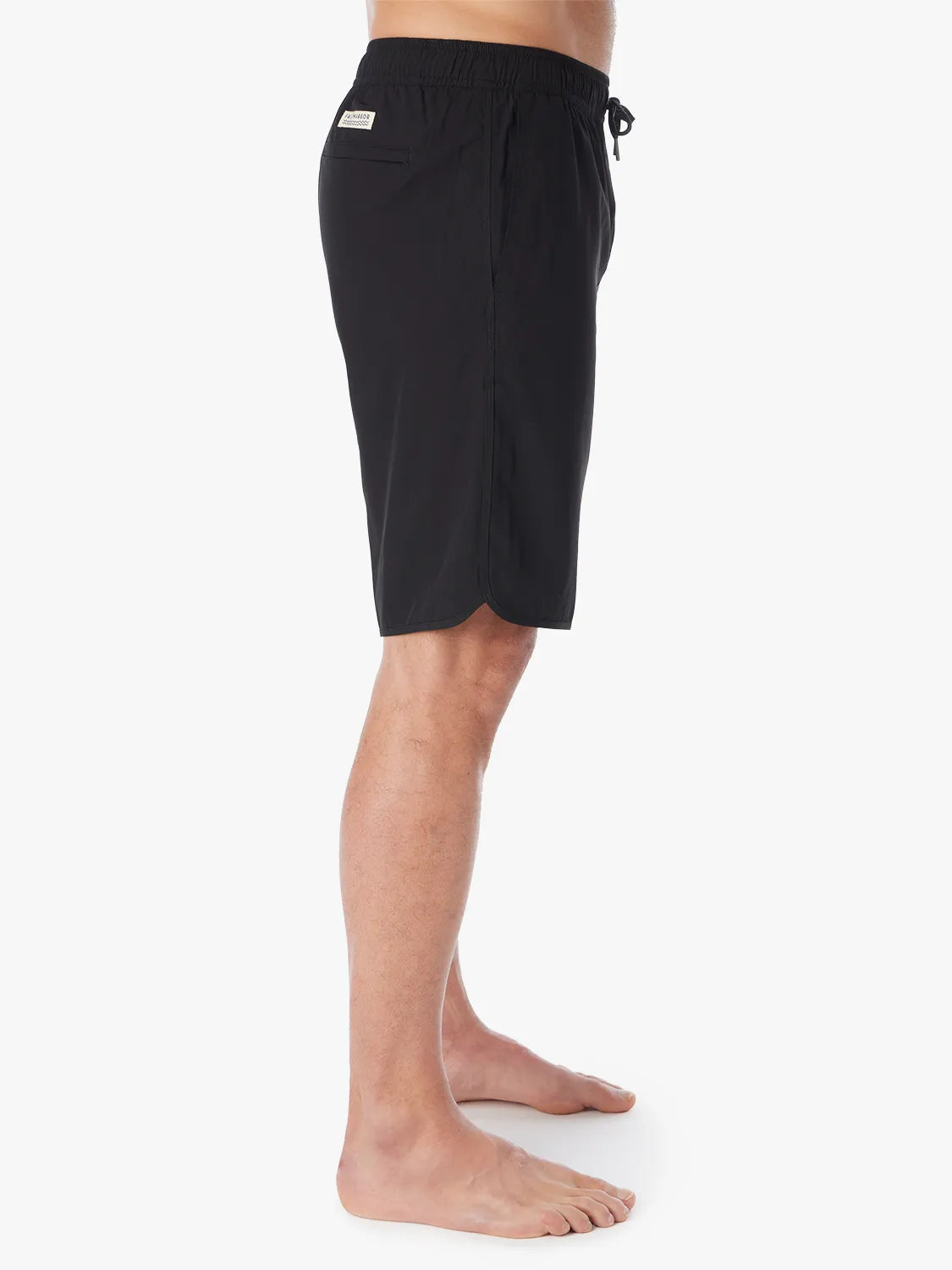 A person wearing a pair of black 10 inch Anchor Trunks on a white background, showing the side view. 