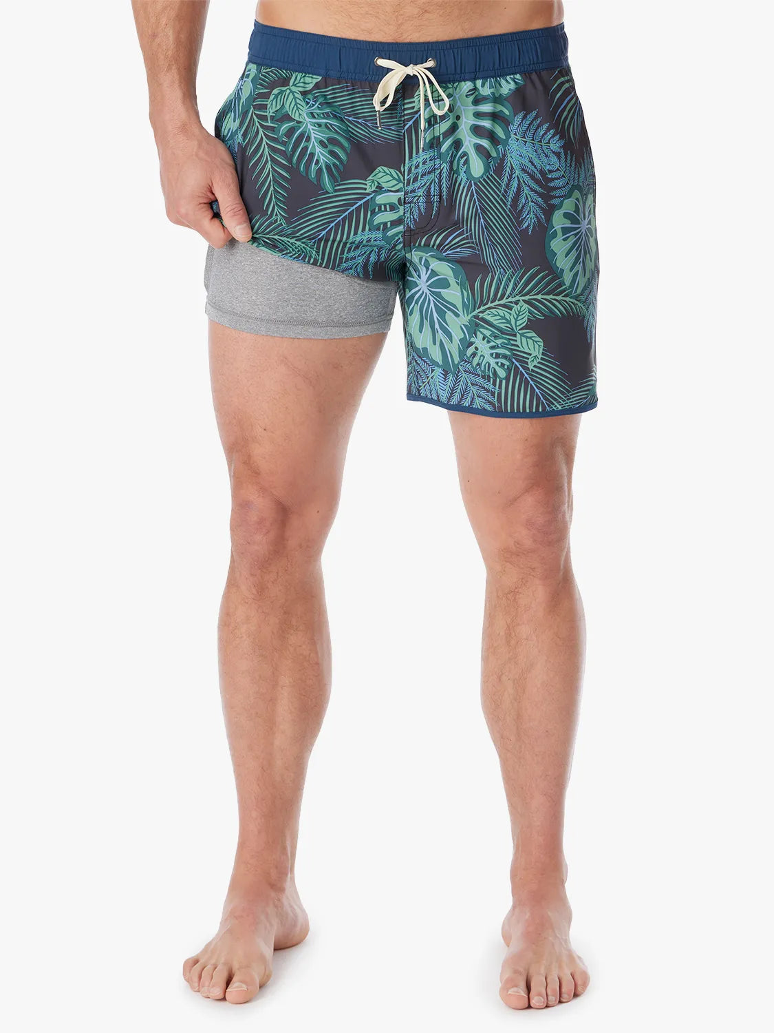 A pair of Anchor Trunk in 6 inch inseam with a navy blue and green leaf pattern, featuring a drawstring waist and showing the liner on a white background. 