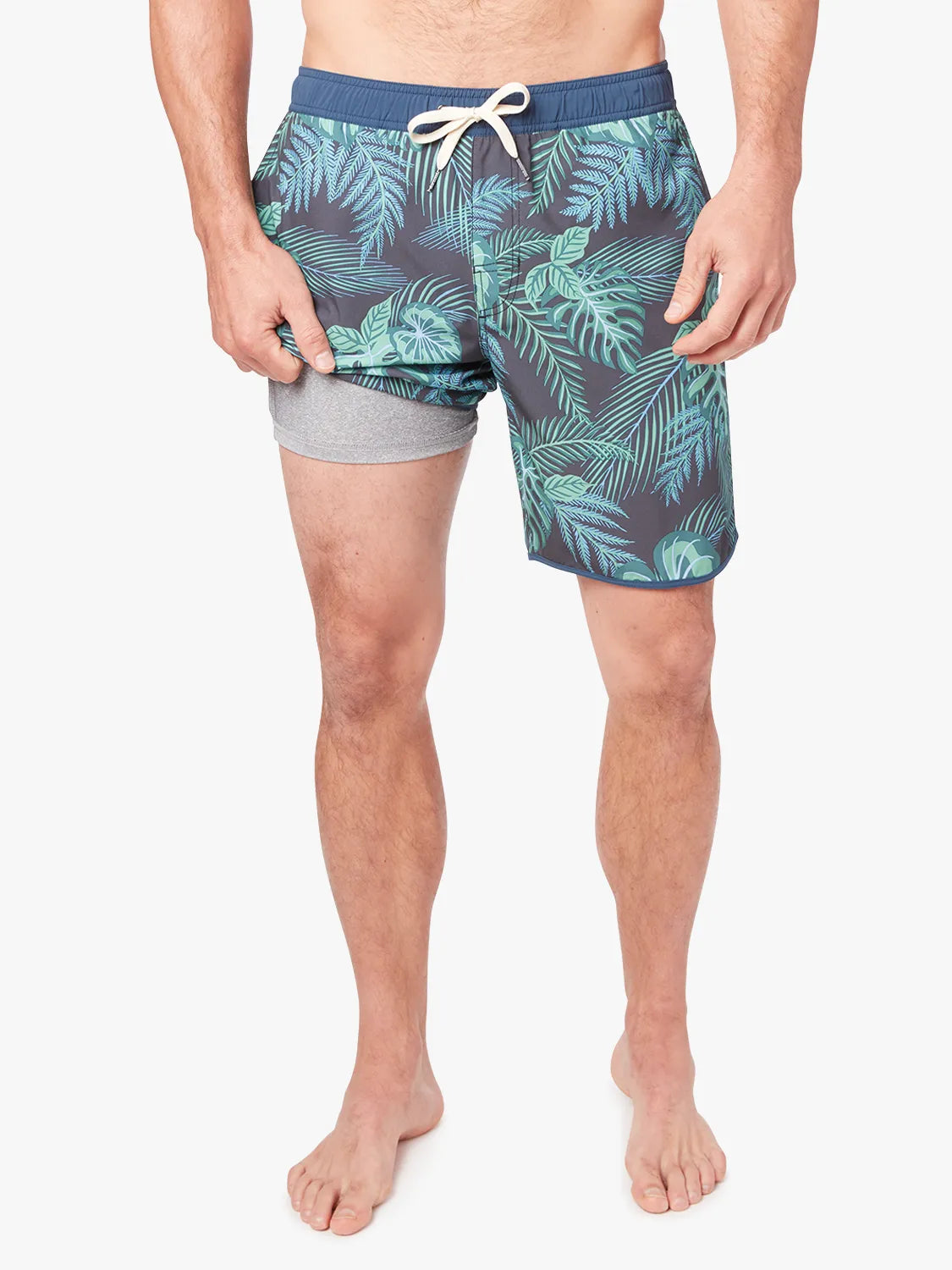 A pair of Anchor Trunk in 8 inch inseam with a navy blue and green leaf pattern, featuring a drawstring waist and showing the liner on a white background. 