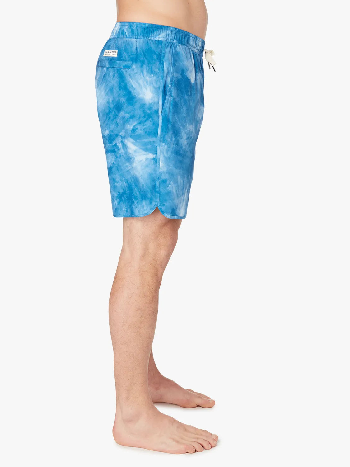 A person wearing a pair of blue tie-dye Anchor Trunk in 8 inch inseam with a drawstring waist and showing side view. 
