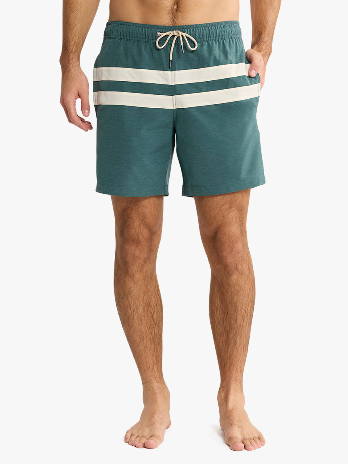 Person wearing teal swim shorts with white stripes on a white background