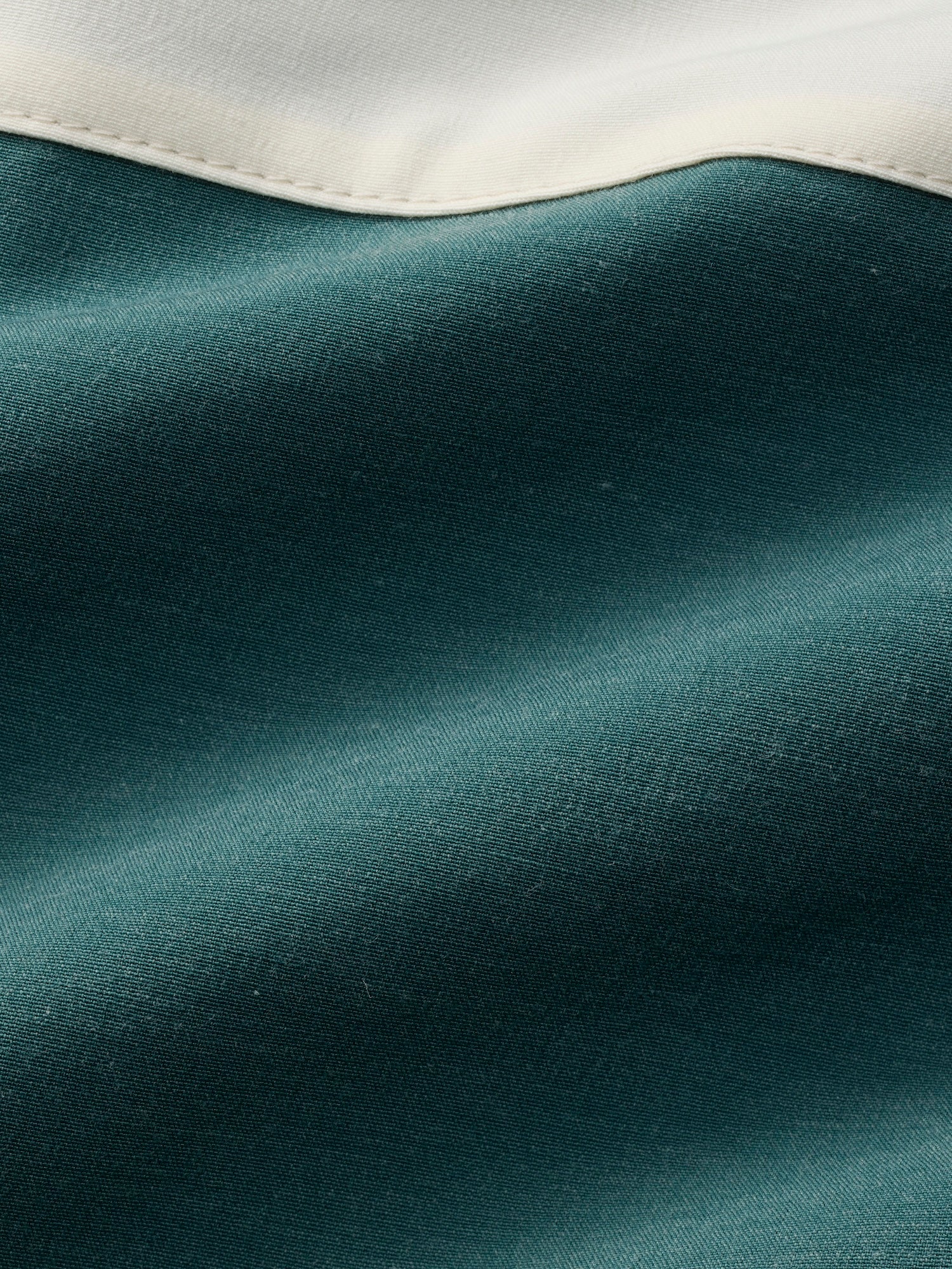 Close-up of teal fabric with a white border