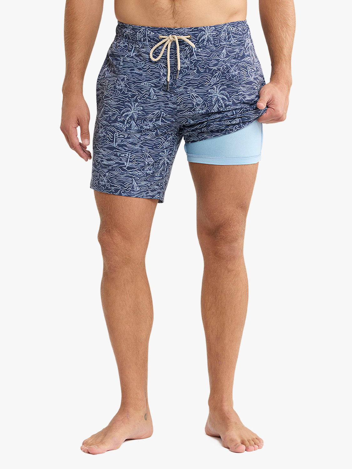 Person wearing blue patterned swim shorts on a white background