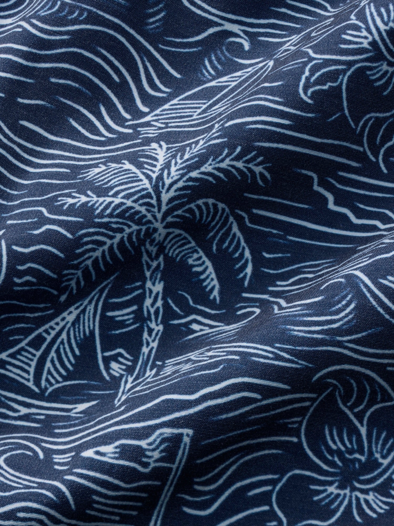 Navy blue fabric with white palm tree and wave pattern