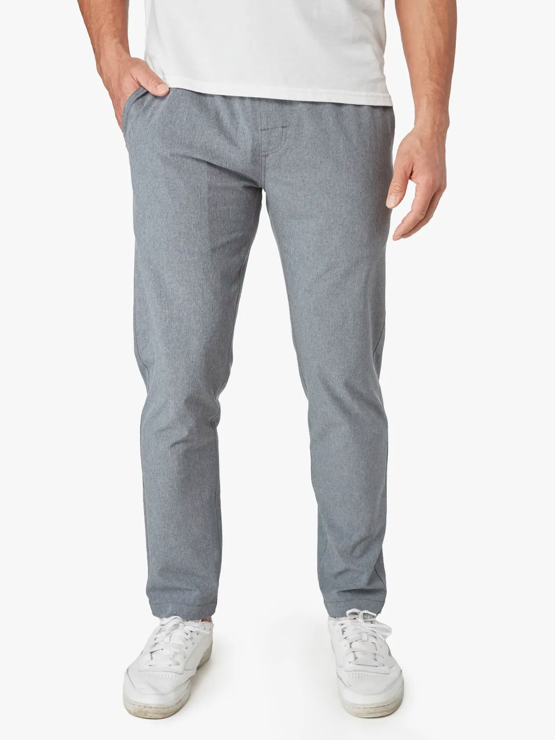 Person wearing a pair of grey one pant with a drawstring on a white background. Pairing with white shirt and sneakers. 