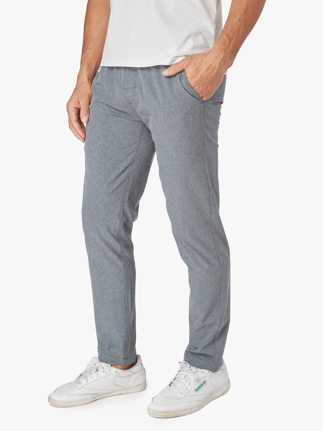 Person wearing a pair of grey one pant with a drawstring on a white background. Pairing with white shirt and sneakers. 