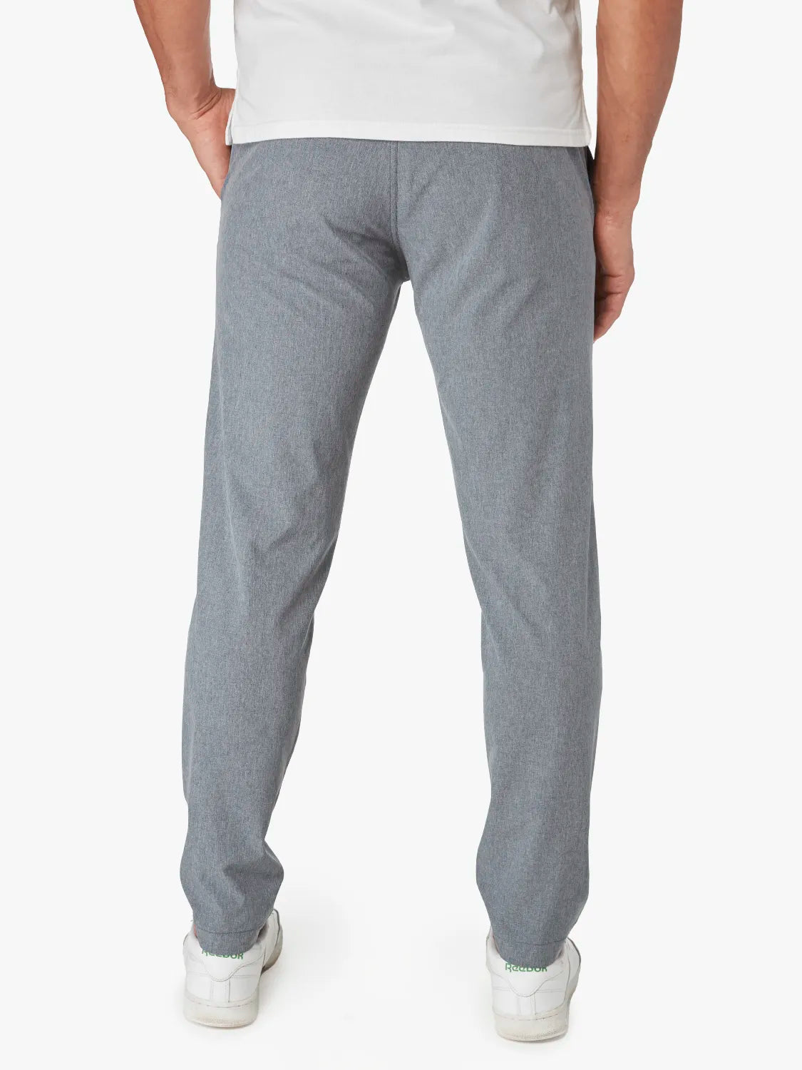 Person wearing a pair of grey one pant with a drawstring on a white background. Pairing with white shirt and sneakers, showing the back view. 