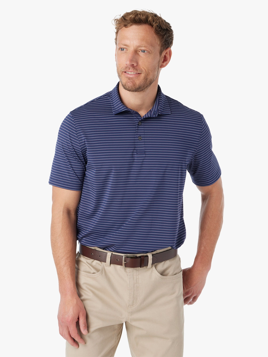 Man wearing navy blue striped compass polo shirt on a white background, paired with khaki pants. 