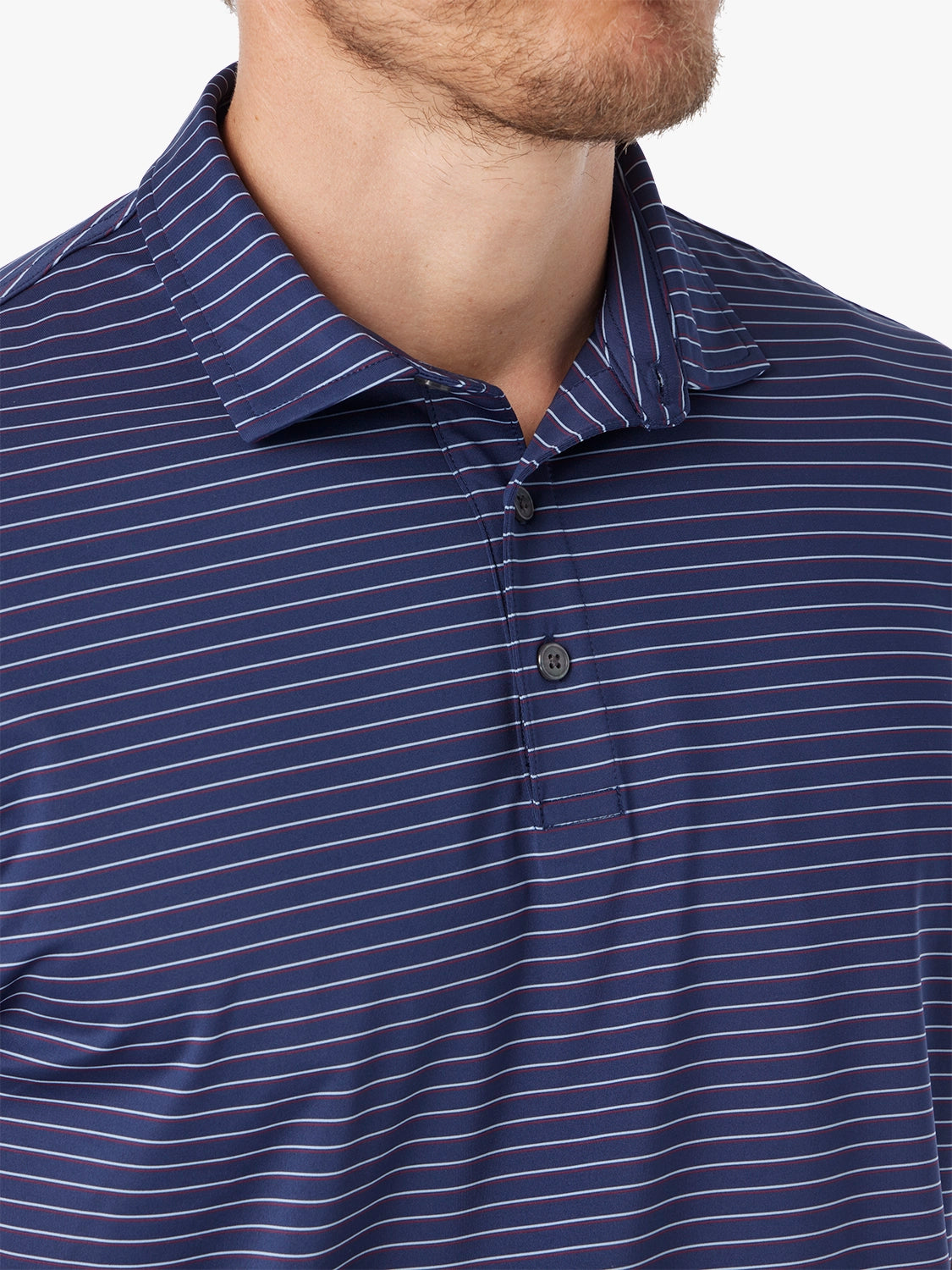 Close-up of a man wearing a blue striped polo shirt showing the stripe pattern with a white background. 