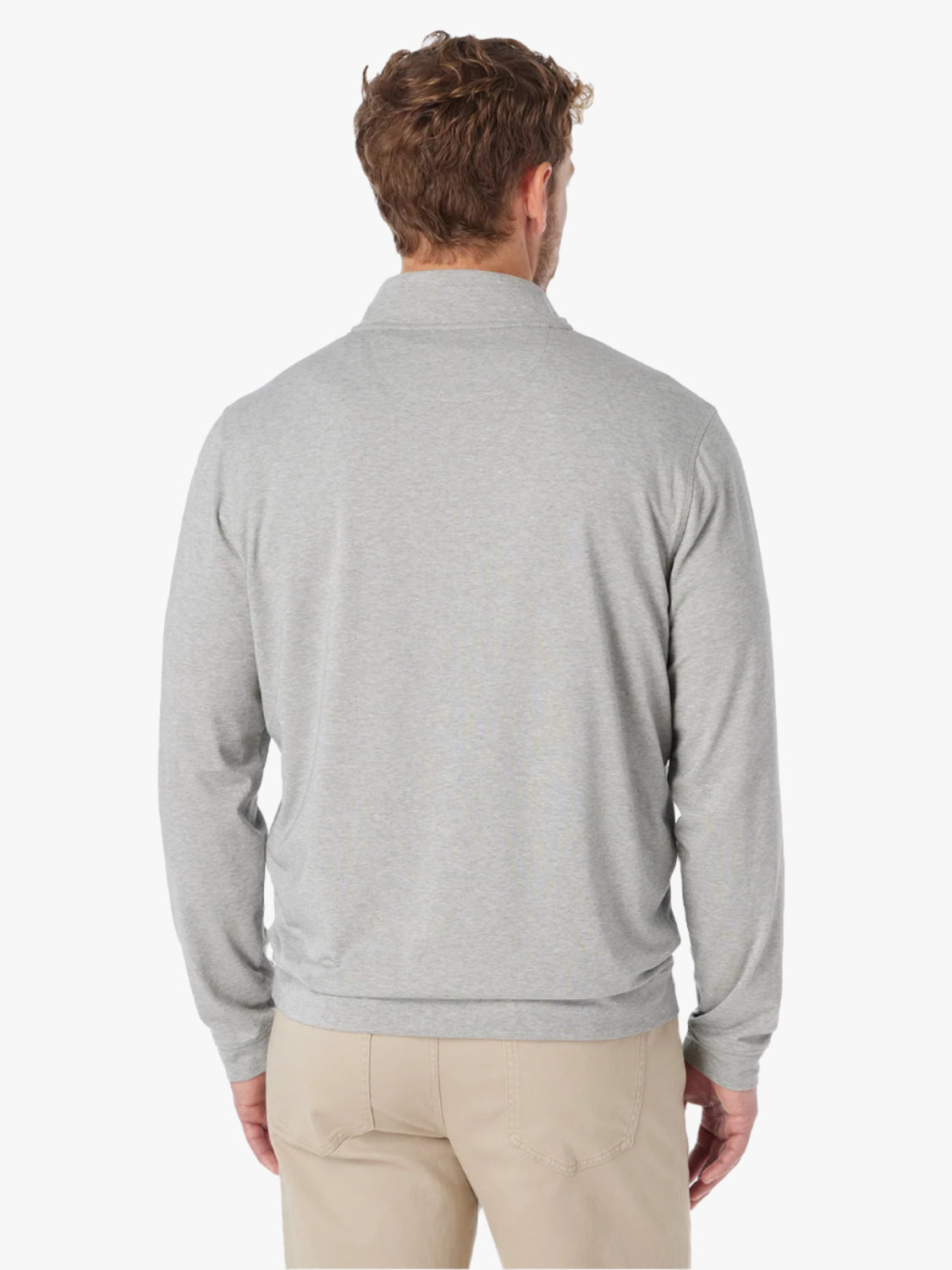 Man wearing heather grey compass pullover with view of back of pullover on a white background, paired with  khaki pants. 