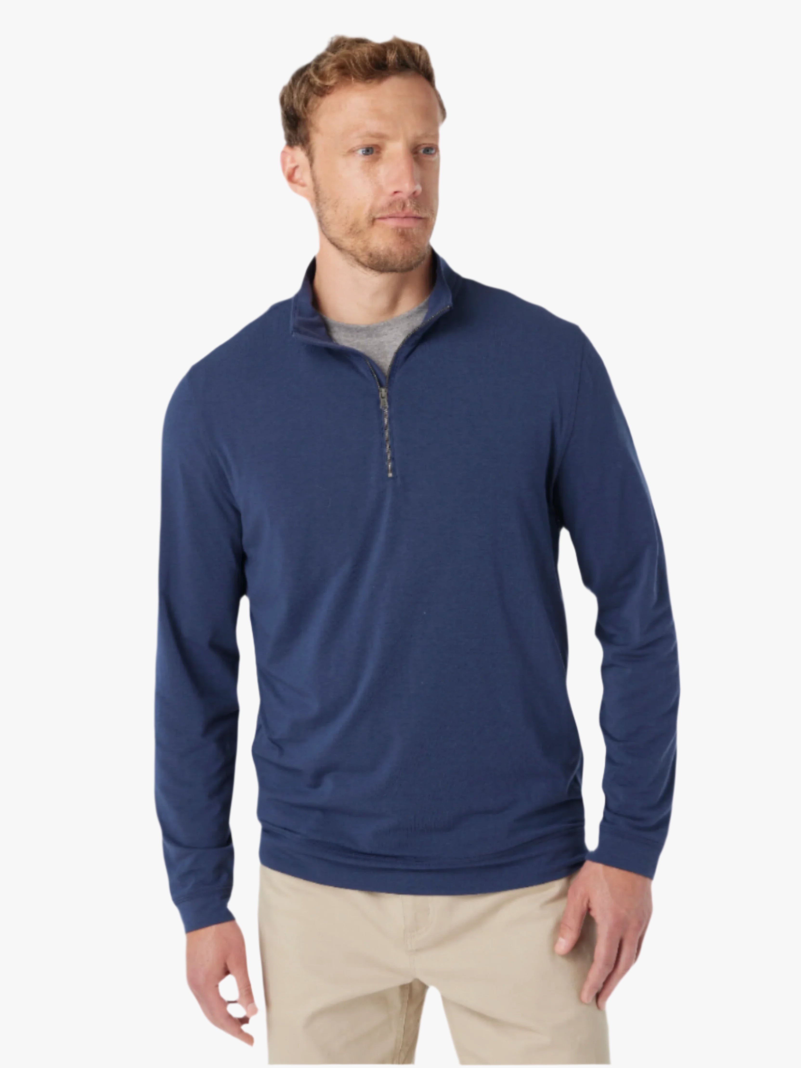 Man wearing a navy blue pullover with a quarter zip on a white background, paired with khaki pants