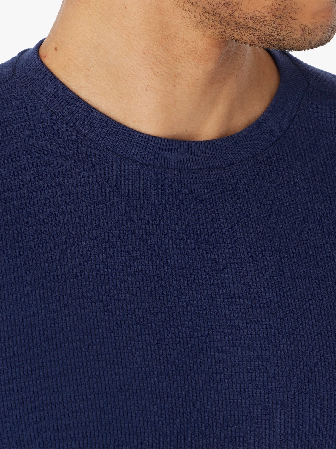 Navy blue waffle fabric shirt worn by a person, focusing on the neckline.