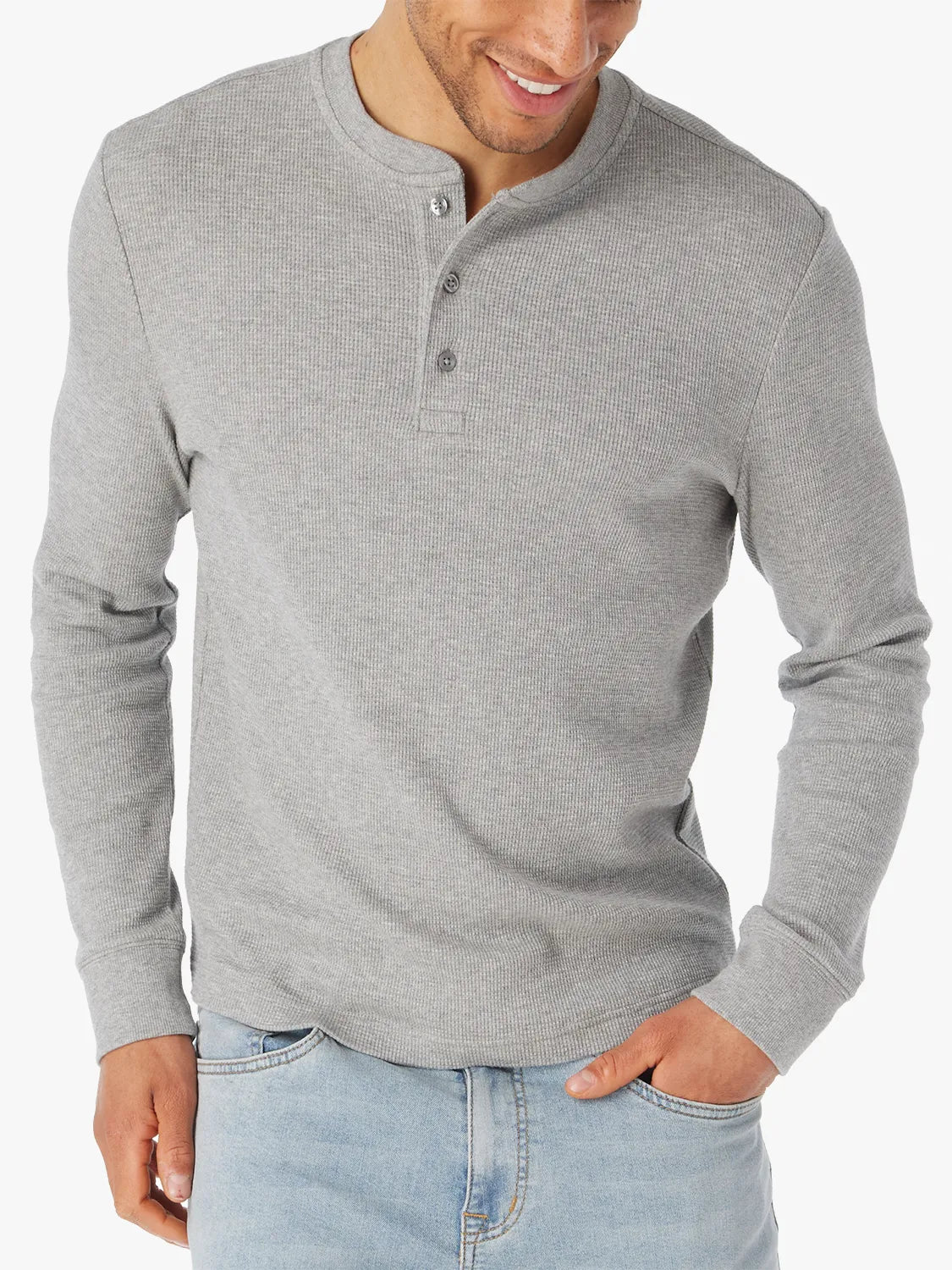 Man wearing a gray long-sleeve waffle henley shirt with a white background