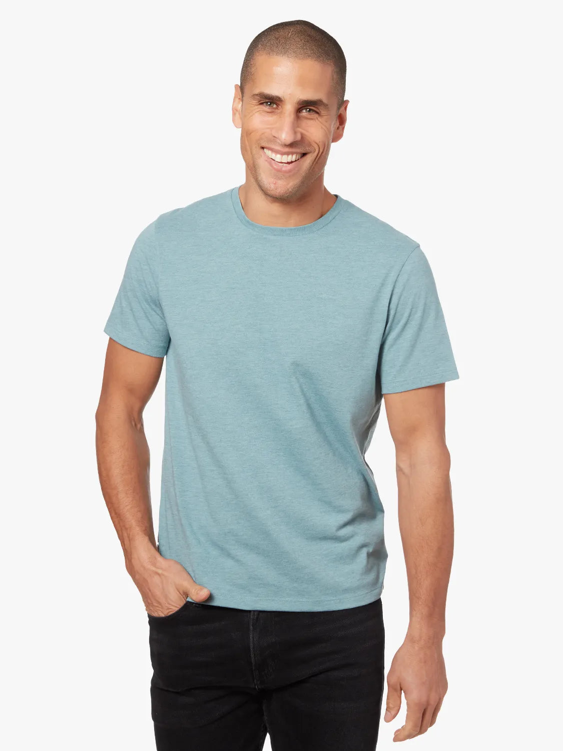 Person wearing heather light green kismet t-shirt on a white background, paired with driftwood denim pants. 