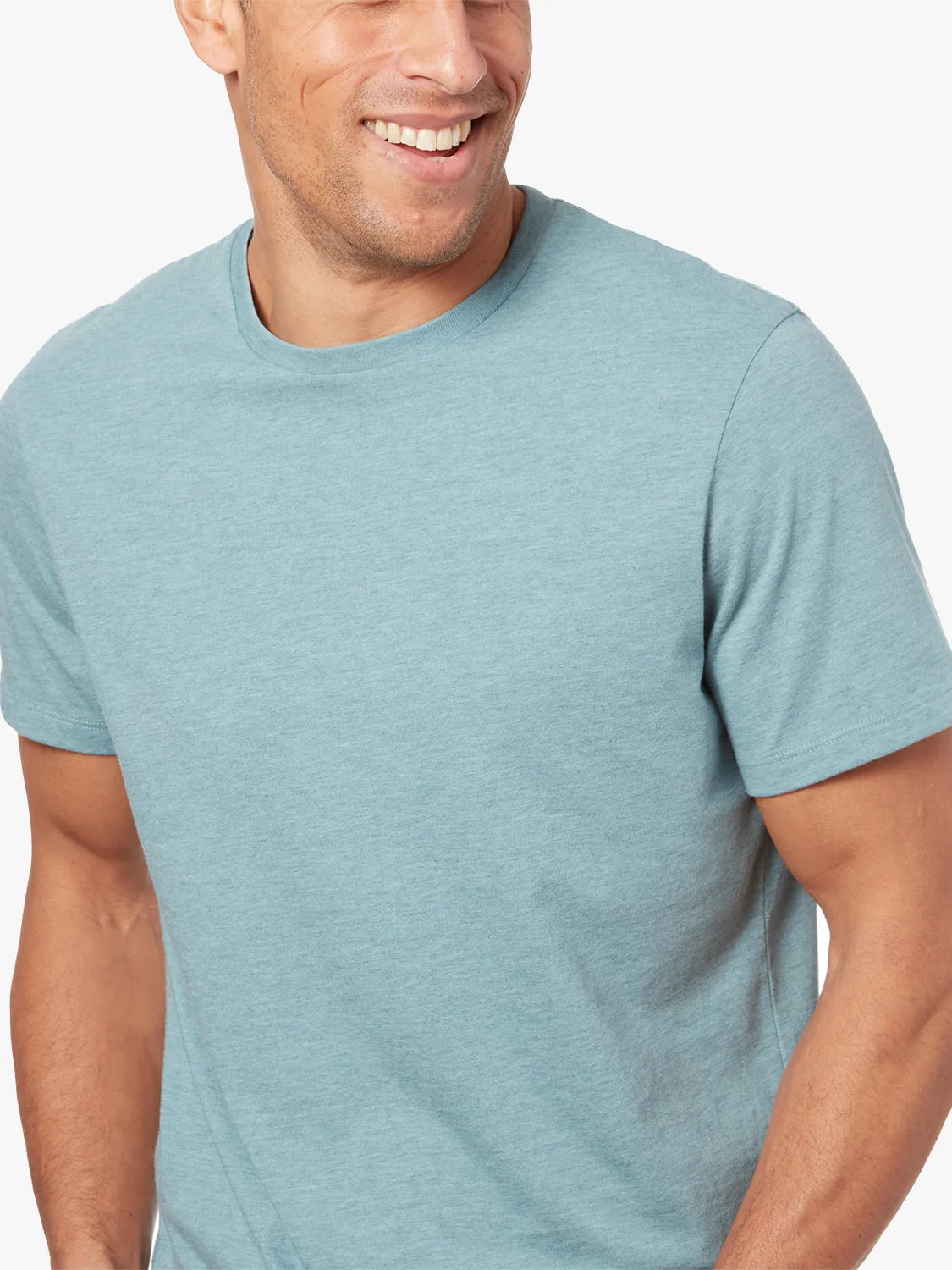 Person wearing heather light green kismet t-shirt on a white background. 