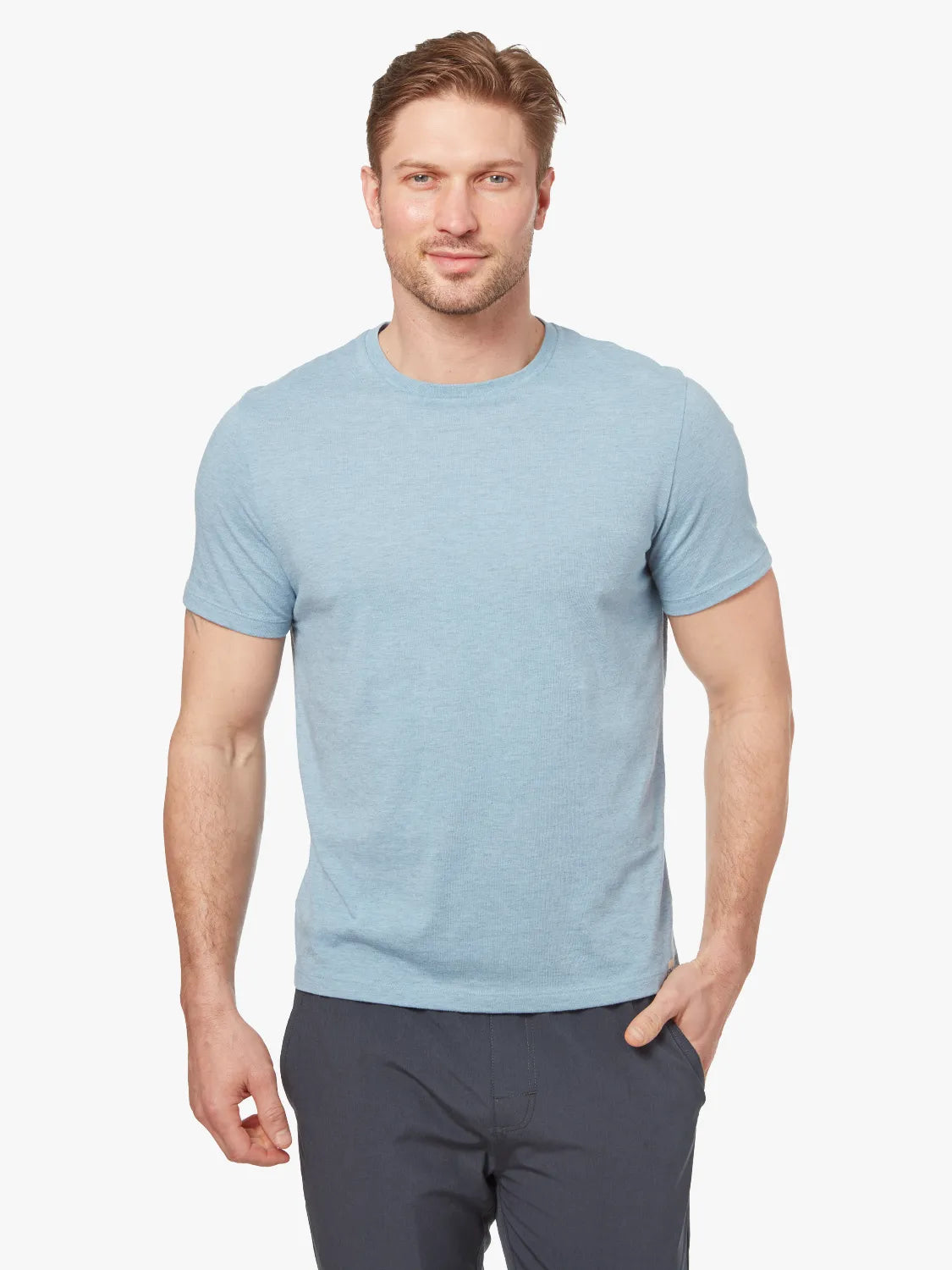 Person wearing light blue kismet t-shirt on a white background, paired with black one pants. 