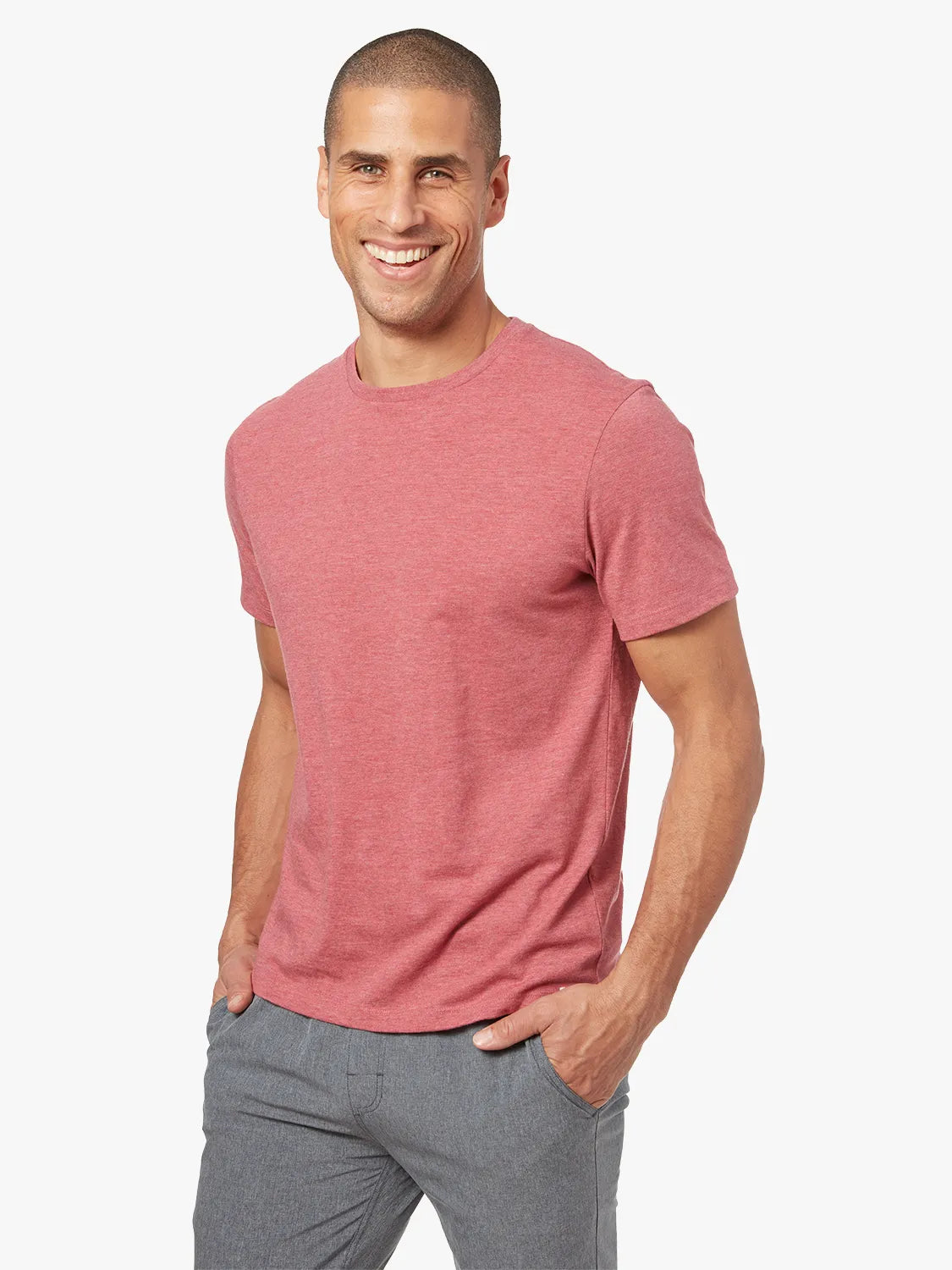 Person wearing red kismet t-shirt on a white background, paired with grey one pants. 