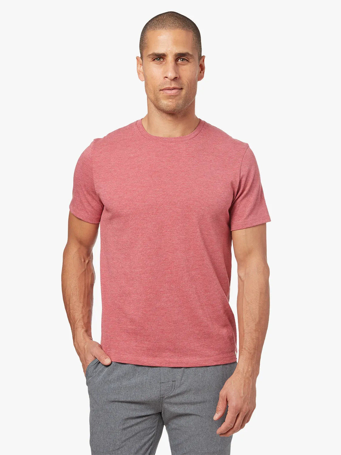 Person wearing red kismet t-shirt on a white background, paired with grey one pants. 