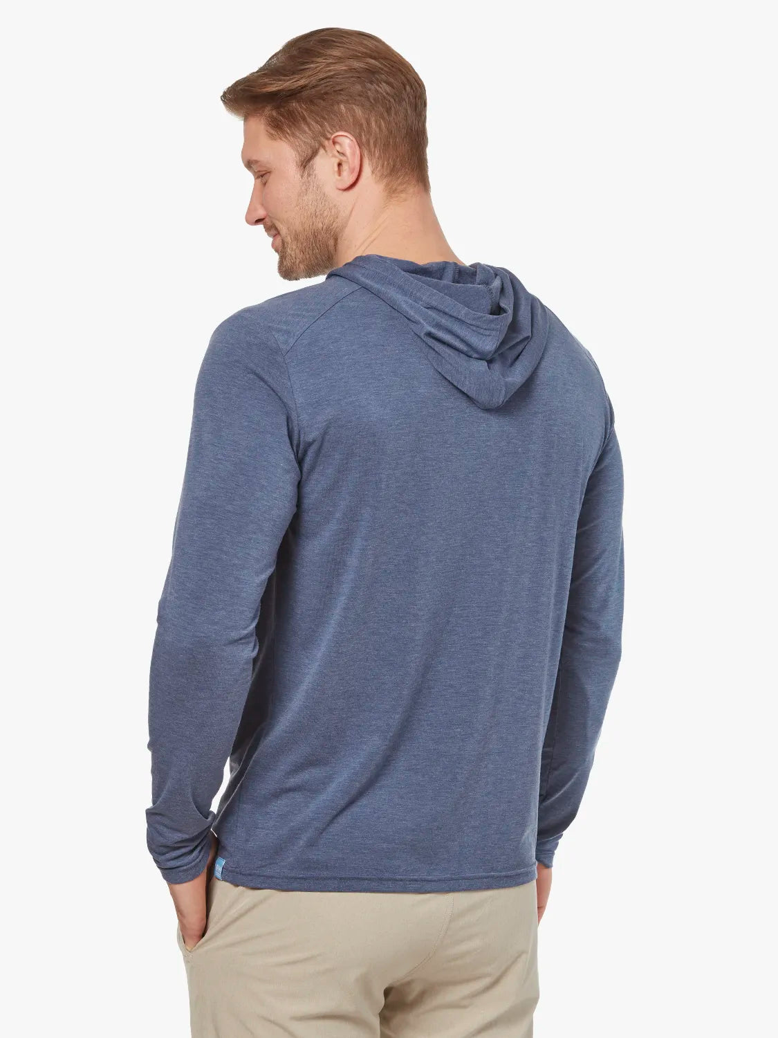 Person wearing navy blue seabreeze hoodie on a white background, paired with khaki pants. Showing the back view of hoodie. 