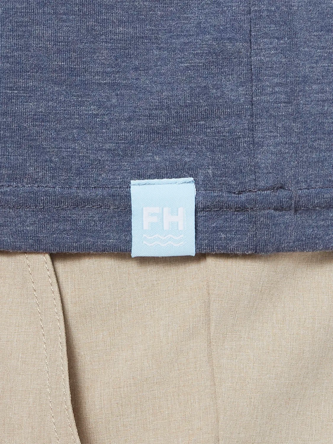 Close up of wearing navy blue seabreeze hoodie showing the fabric and brand logo patch.  