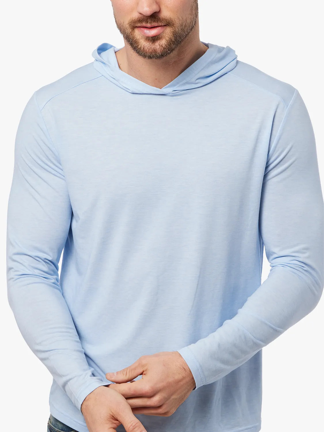 Clouse up of person wearing light blue seabreeze hoodie on a white background, showing the fabric. 