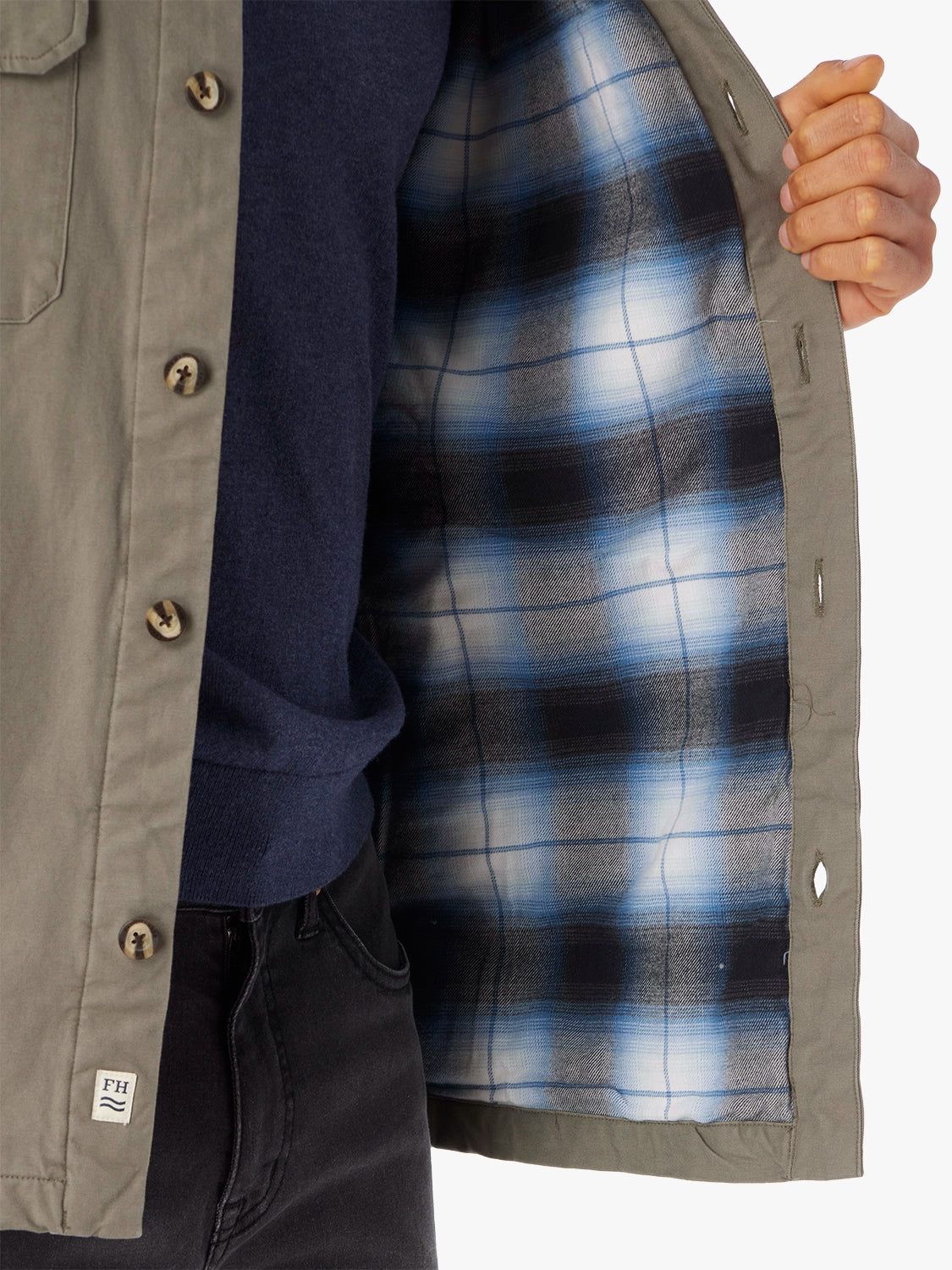 Close up of olive green montauk jacket showing the plaid lining on a white background