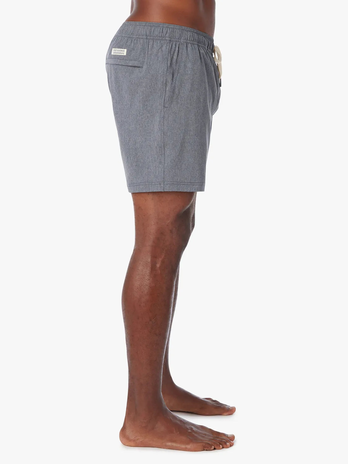 Man wearing a grey one shorts in 6 inch inseam with a drawstring on a white background, showing the side view.